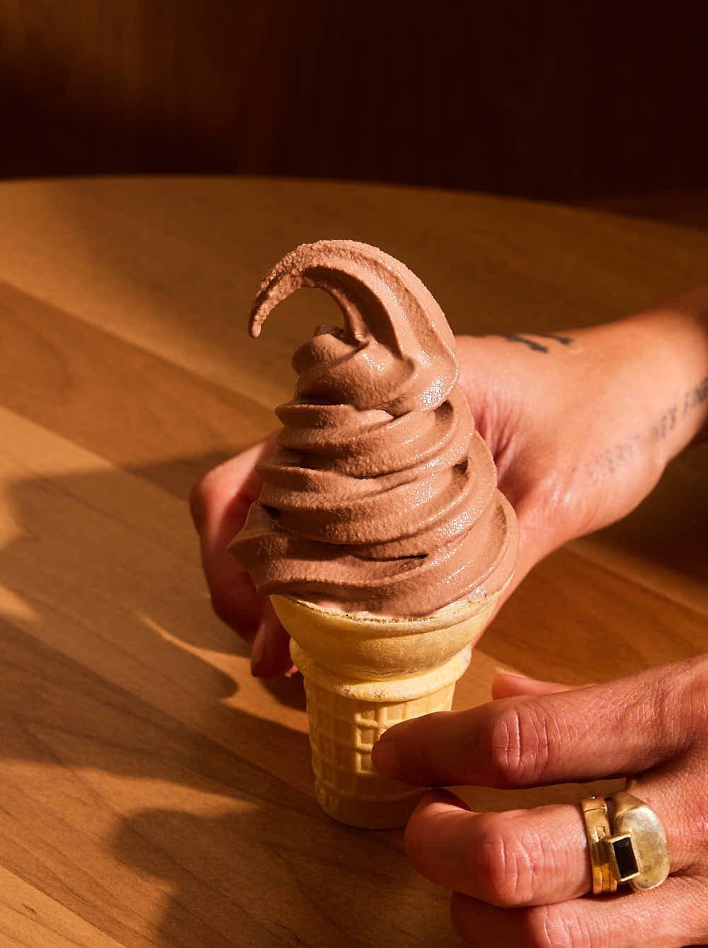 Chocolate soft serve cone in hand