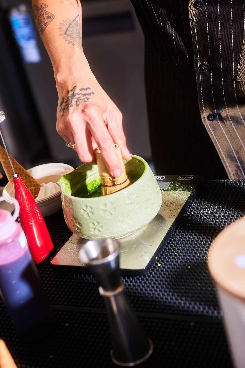 Matcha being whisked by hand at the counter