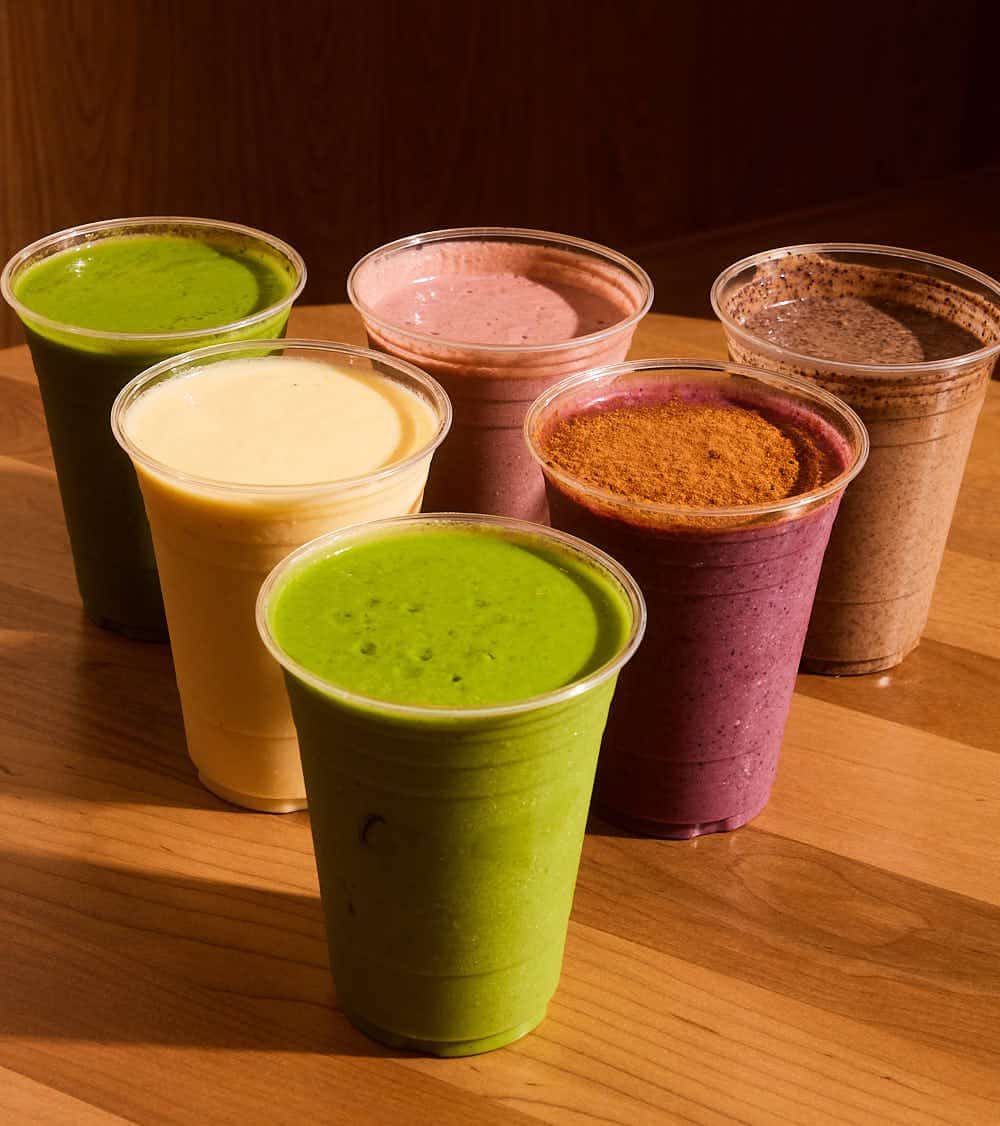 Lulu Dae's protein smoothies lined up on a wooden table